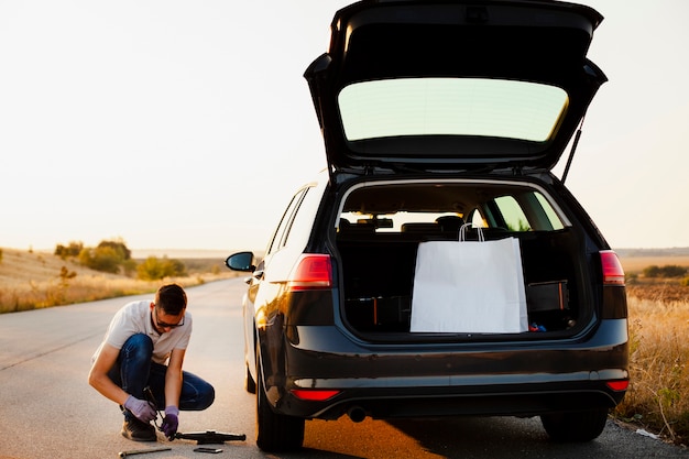 Joven preparándose para reparar el auto