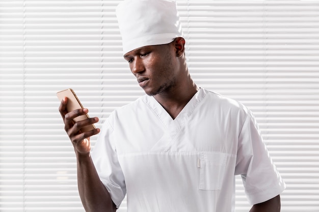 Joven profesional médico usando su teléfono móvil