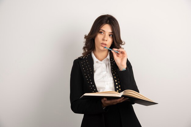 Joven profesora pensando en qué escribir para la próxima clase.