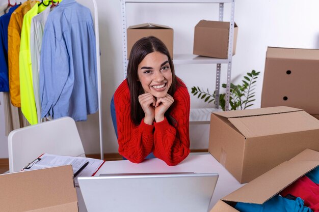 Joven propietaria de una pequeña empresa empacando productos en cajas preparándolos para la entrega Mujeres empacando paquetes con sus productos que vende en línea