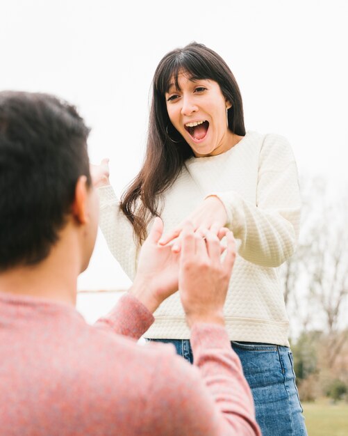 Joven proponiendo a novia emocionada