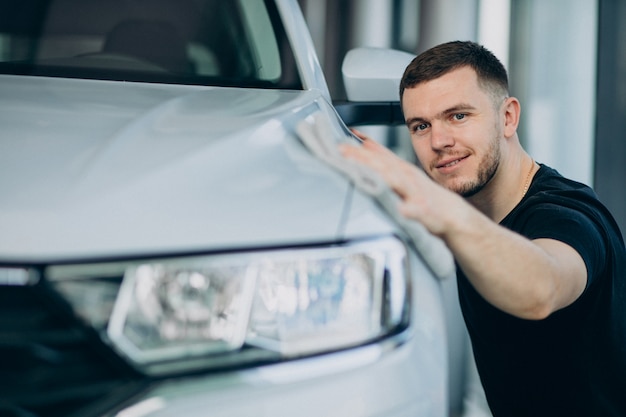 Joven puliendo su auto con un trapo