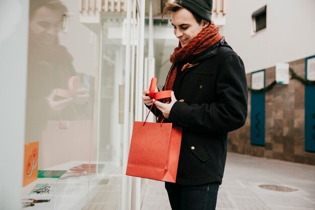 Joven con regalo y bolsa