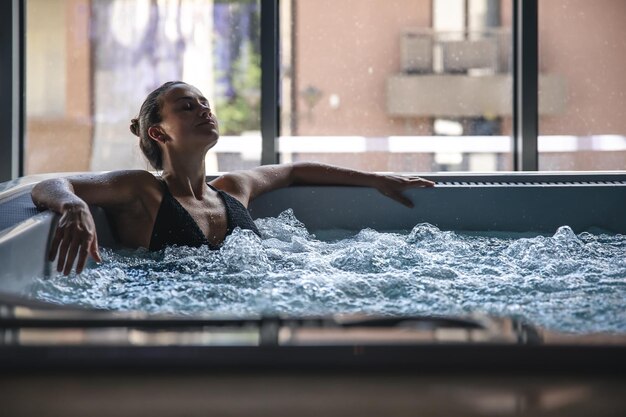 Una joven se relaja en un jacuzzi.