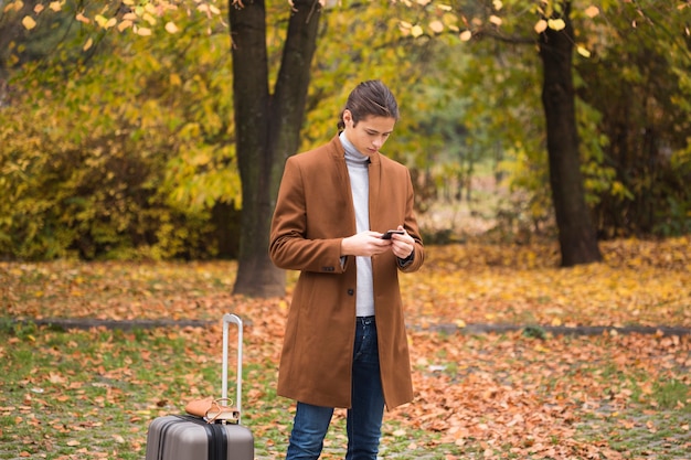 Joven revisando su teléfono en el parque