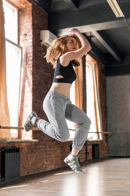 Joven rubia bailando en el estudio de danza