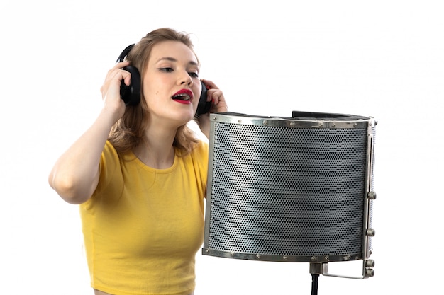 Foto gratuita joven rubia con camiseta amarilla cantando