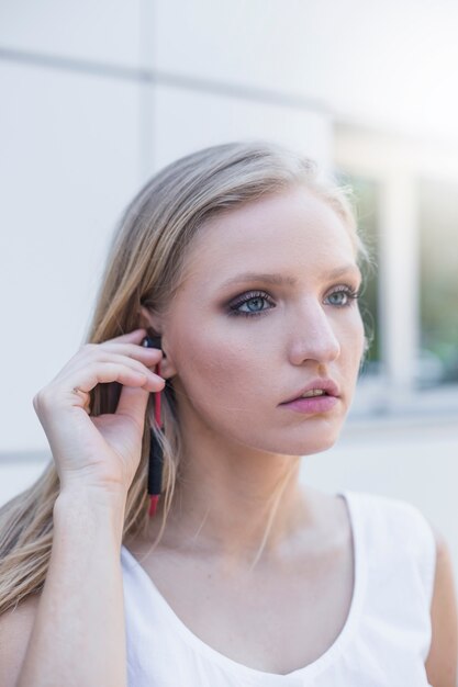 Joven rubia escuchando música en el auricular