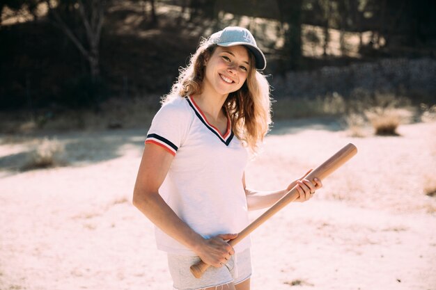 Joven rubia en gorra con gorra de béisbol en la naturaleza