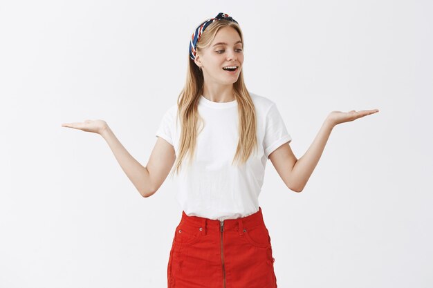 joven rubia posando contra la pared blanca