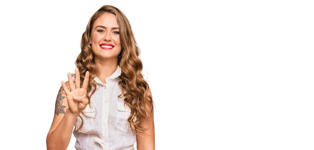 Joven rubia con ropa informal que aparece y señala con los dedos número cuatro mientras sonríe confiada y feliz.