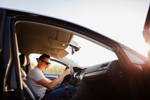 Joven sentado en el auto