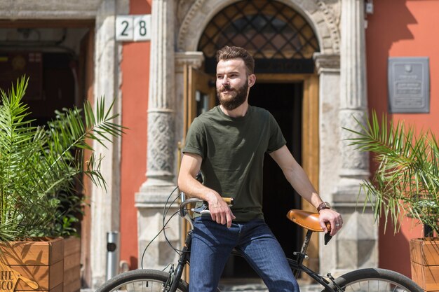 Joven sentado en bicicleta al aire libre