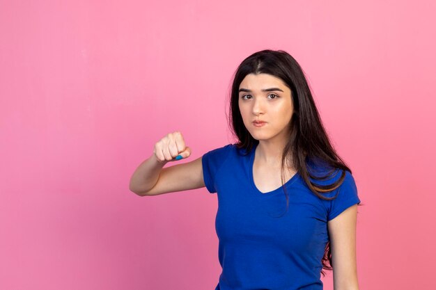 Una joven seria aprieta el puño y mira la cámara Foto de alta calidad