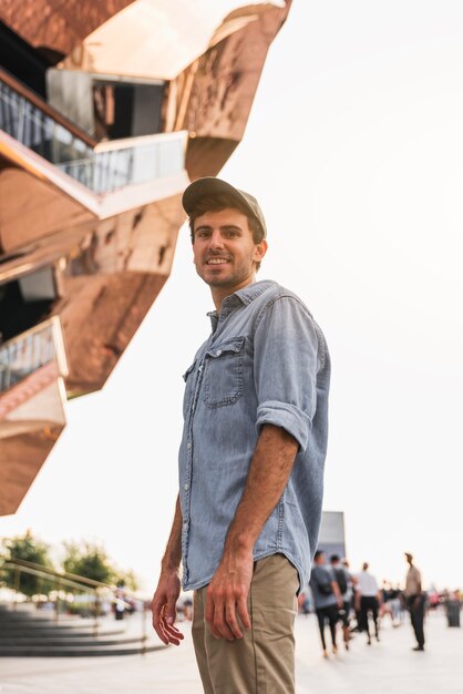 Joven sonriendo cerca de un edificio alto