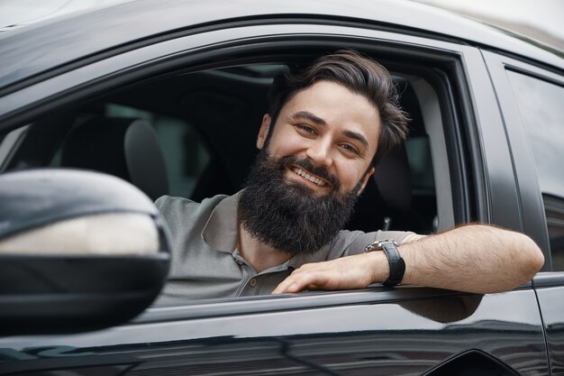 Joven sonriendo mientras conduce un auto