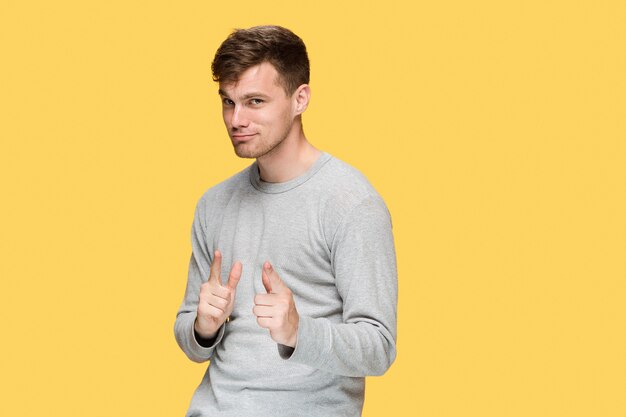 El joven sonriendo y señalando