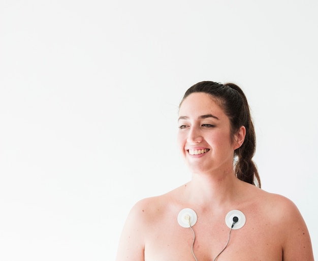 Foto gratuita joven sonriente con electrodos en el cuerpo