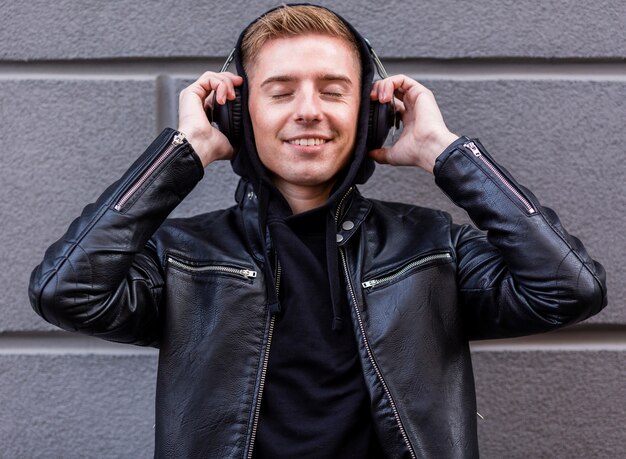 Joven sonriente escuchando música con auriculares