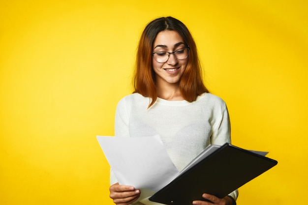 Joven sonriente está buscando en los documentos