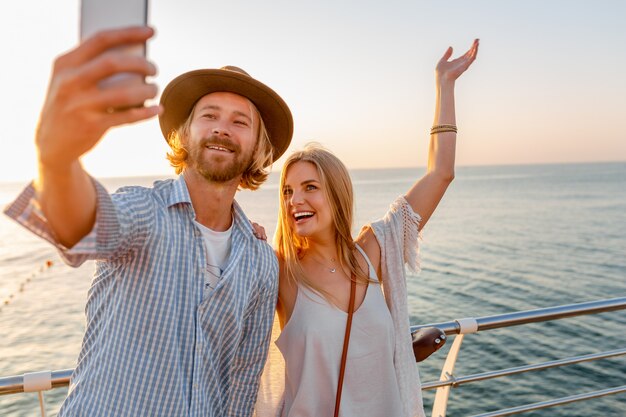 Joven sonriente feliz hombre y mujer viajando en bicicleta tomando selfie foto en la cámara del teléfono