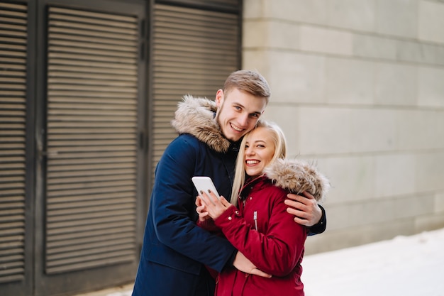 Joven sonriente feliz pareja europea abrazando en invierno