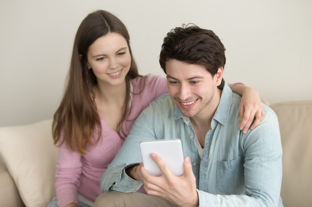 Joven sonriente feliz pareja usando tableta, videollamada, tienda online