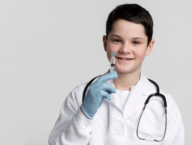 Joven sonriente con jeringa médica