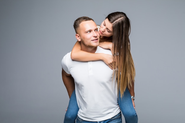 Joven sonriente con novia sobre su espalda en el estudio