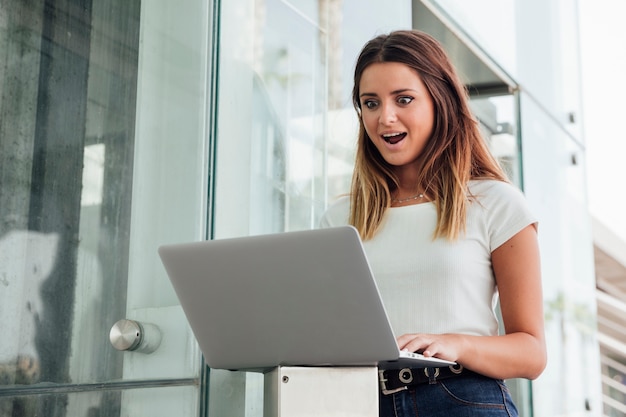 Joven sorprendida con una computadora portátil