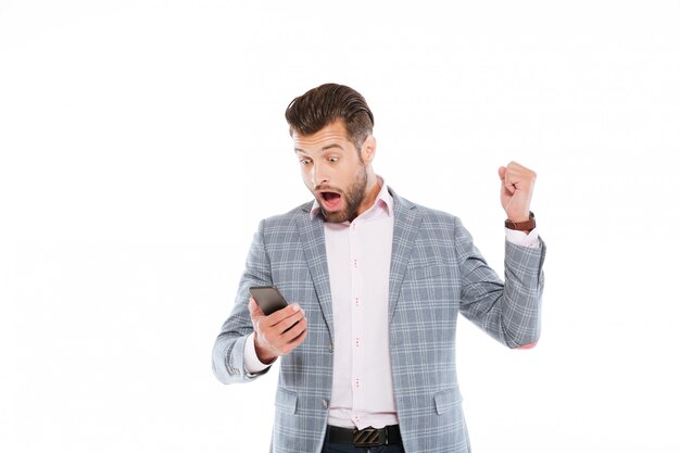 Joven sorprendido usando teléfono móvil.