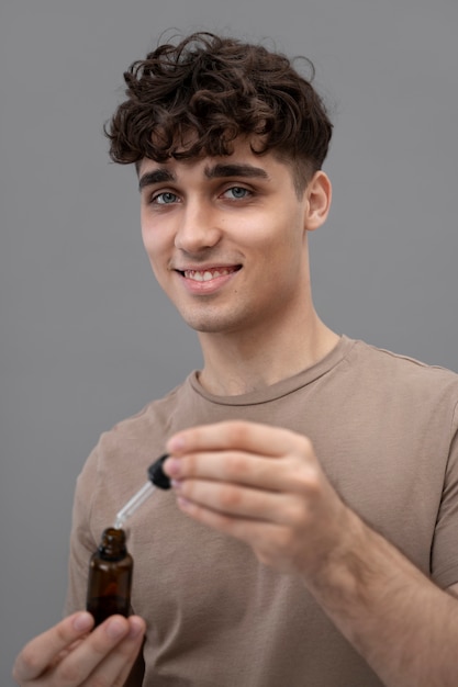 Foto gratuita joven sosteniendo botella de suero