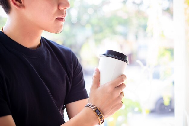 Joven sosteniendo café caliente