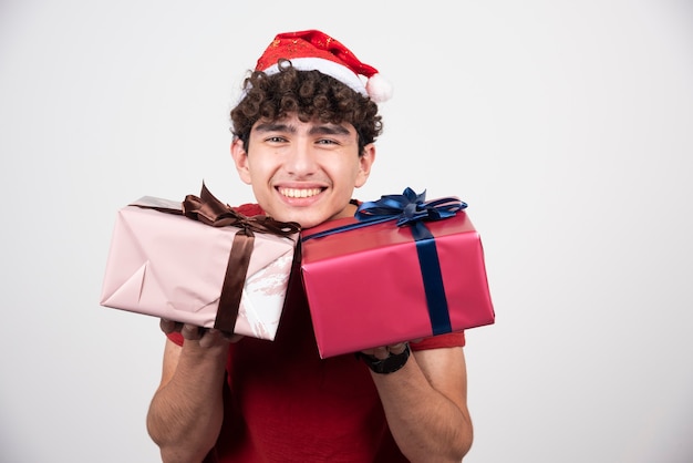 Joven sosteniendo cajas de regalo y sonriendo.