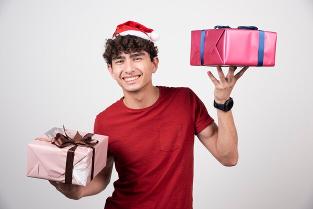 Joven sosteniendo cajas de regalo con sonrisa.