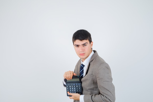 Joven sosteniendo la calculadora en traje formal