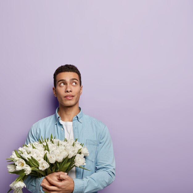 Joven sosteniendo ramo de flores blancas