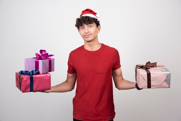 Joven sosteniendo sus regalos de Navidad.