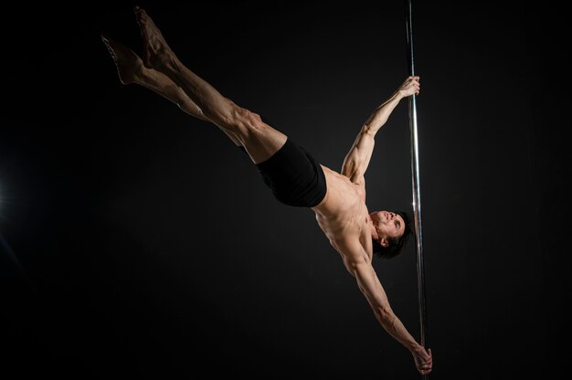 Joven stripper haciendo un pole dance