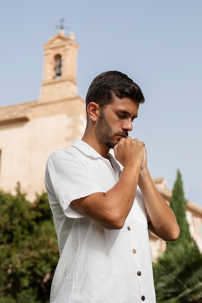 Un joven de tamaño mediano rezando.