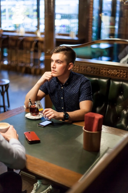 Joven con una taza de té en el restaurante