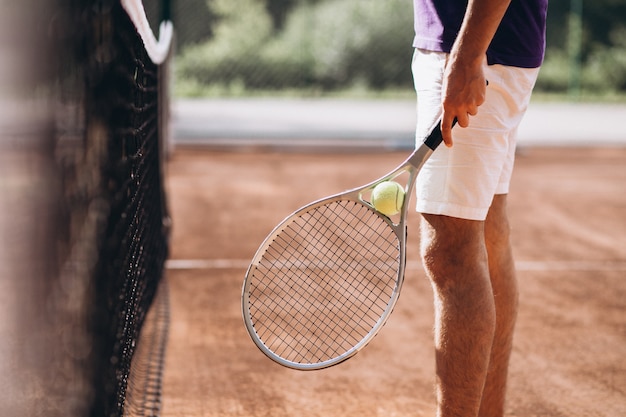 Joven tenista en la cancha, raqueta de tenis de cerca