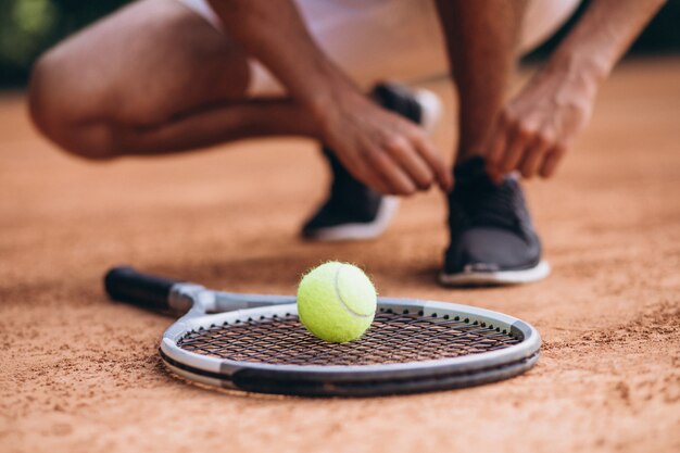 Joven tenista en la cancha, raqueta de tenis de cerca