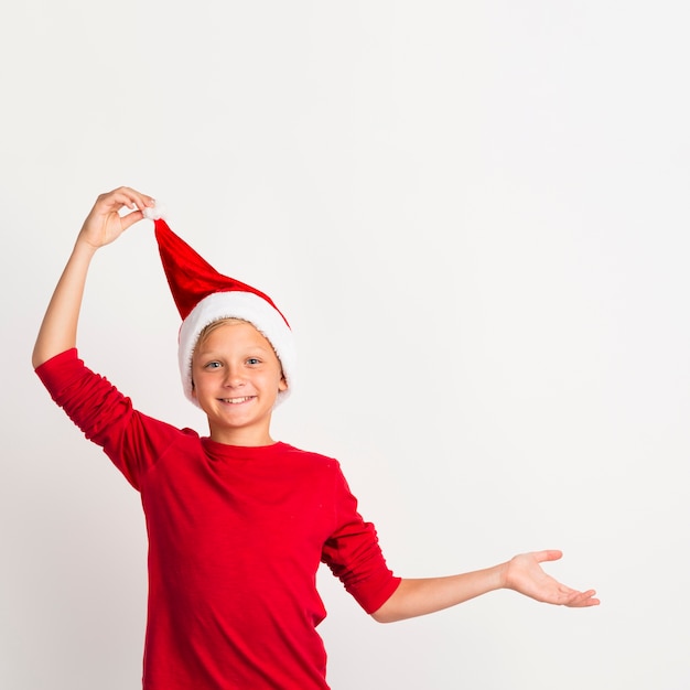 Foto gratuita joven tirando del sombrero de santa