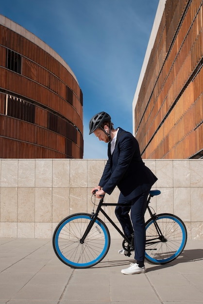 Foto gratuita joven de tiro completo en bicicleta yendo al trabajo