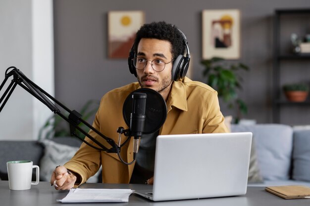 Joven de tiro medio grabando podcast en el estudio