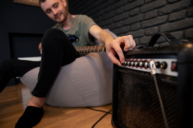 Joven tocando la guitarra en casa