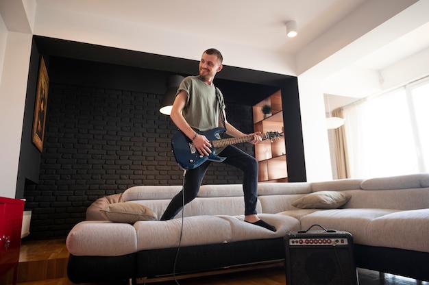 Foto gratuita joven tocando la guitarra en casa