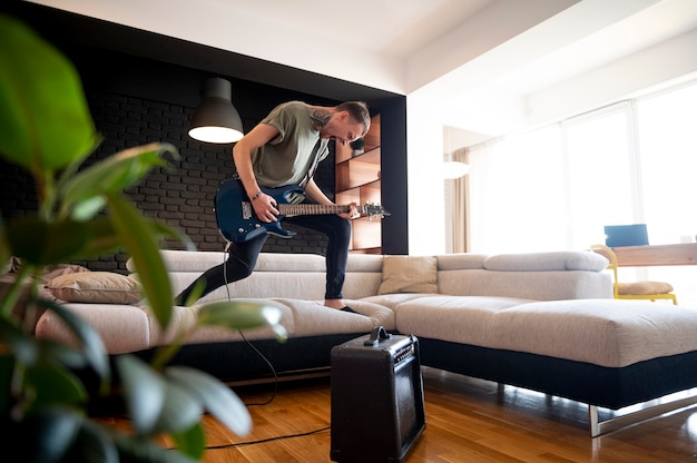 Foto gratuita joven tocando la guitarra en casa