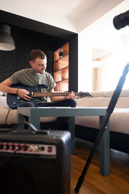 Foto gratuita joven tocando la guitarra en casa